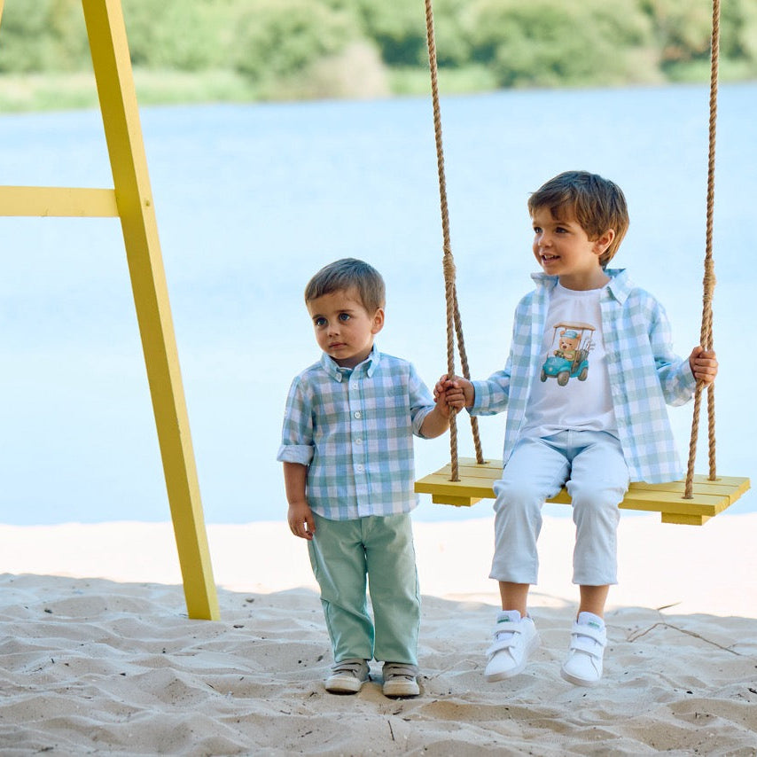 Two children on a swing set by a lake