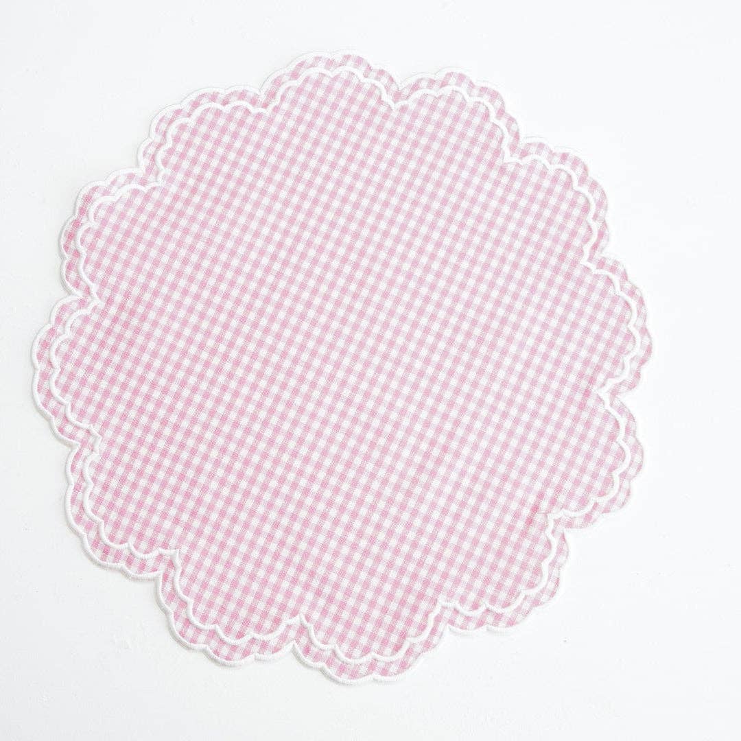 Scalloped pink gingham placemat on a white background