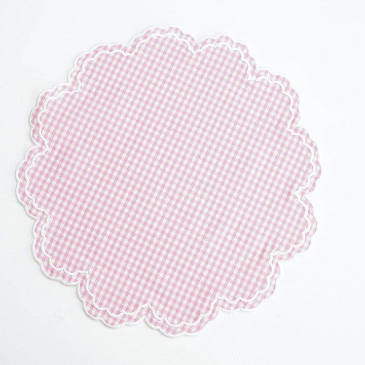 Scalloped pink gingham placemat on a white background