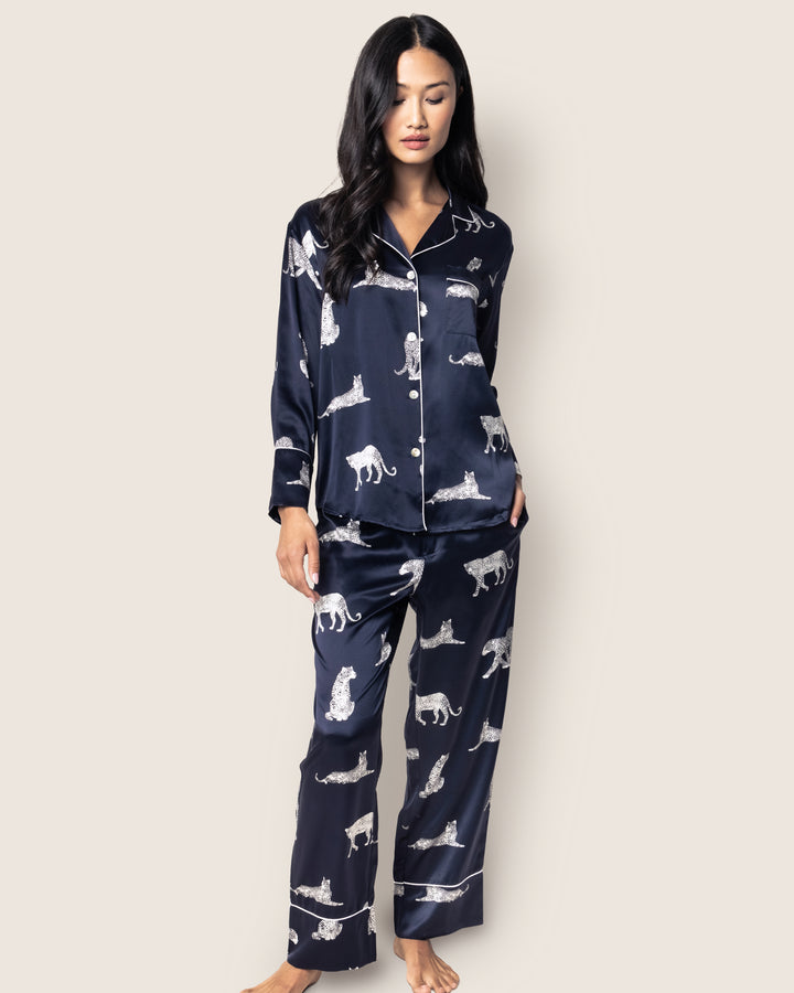 Woman wearing navy blue pajamas with animal print against a white background