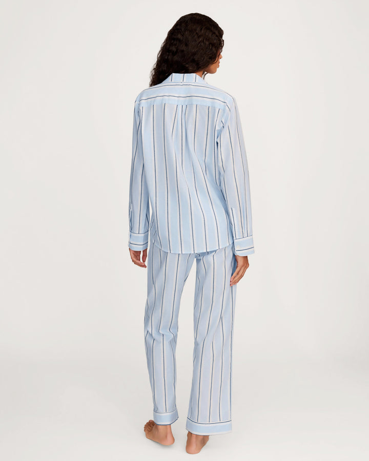 Person wearing a light blue and white striped pajama set on a white background