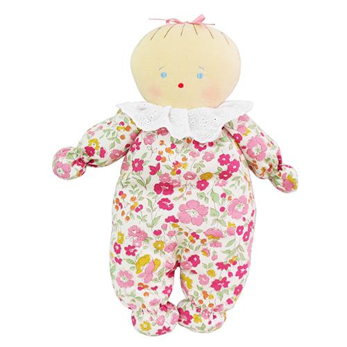 Toy doll wearing a floral onesie on a white background