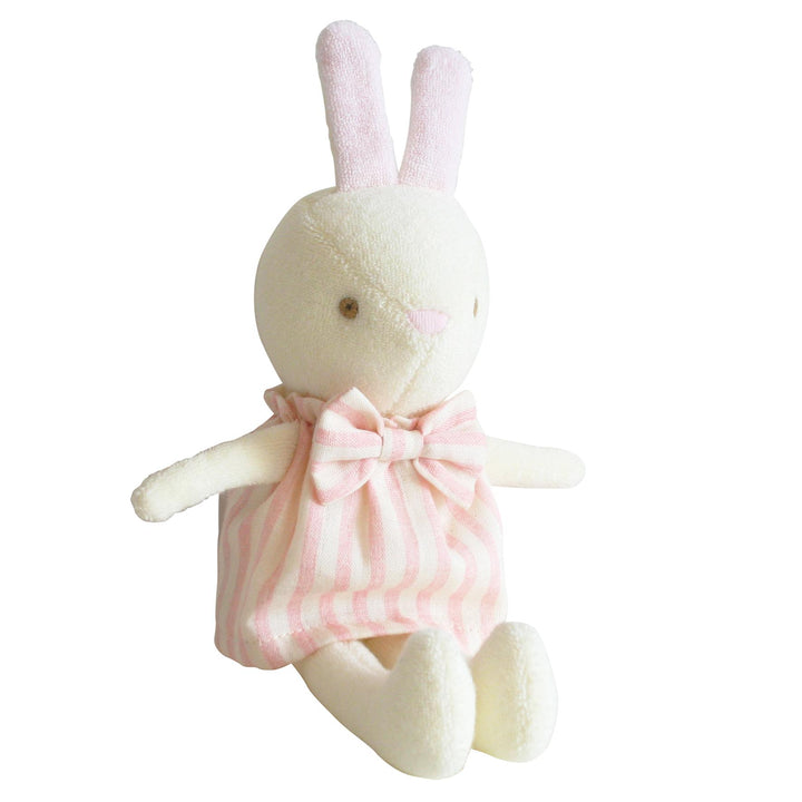 Stuffed toy rabbit with a pink dress on a white background