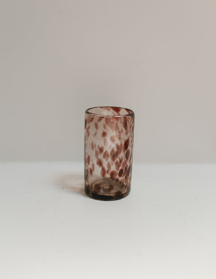 Marbled glass vase on a white surface with a neutral background
