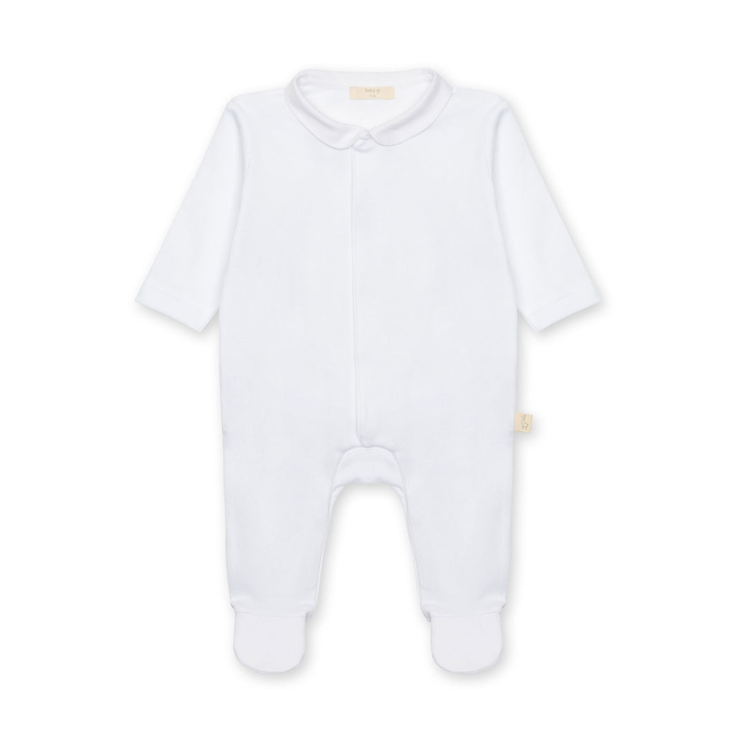 White baby onesie on a light beige background