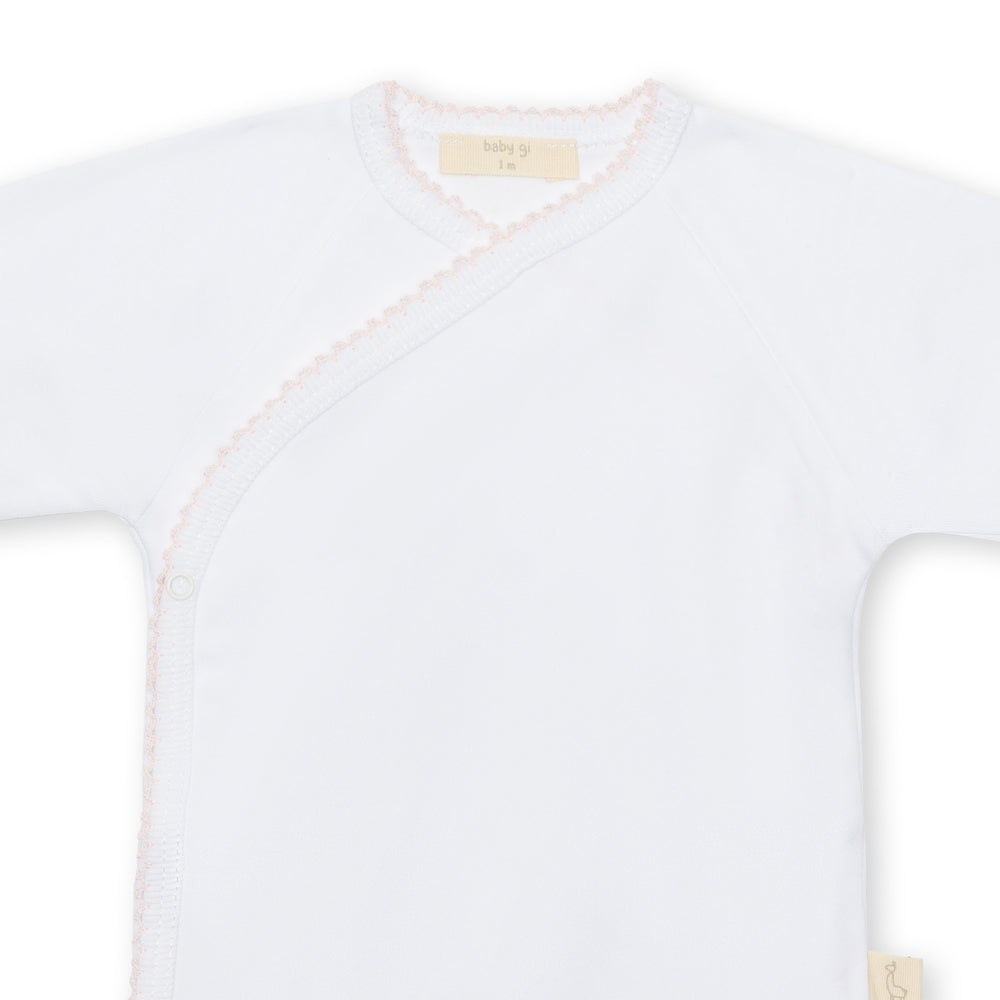 Up close of white newborn onesie with pink trim