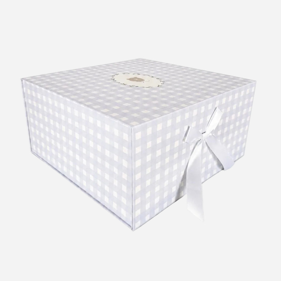 A square gift box with a light gray and white gingham checkered pattern, featuring a white satin ribbon tied in a bow on one side and a small round decorative label on top, set against a plain white background.