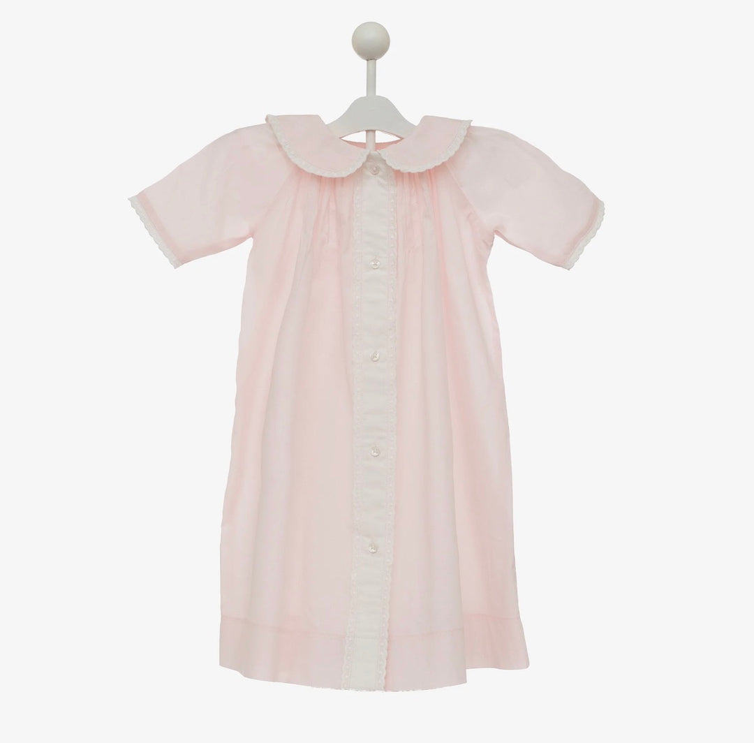 Pink baby dress with a white collar on a white background