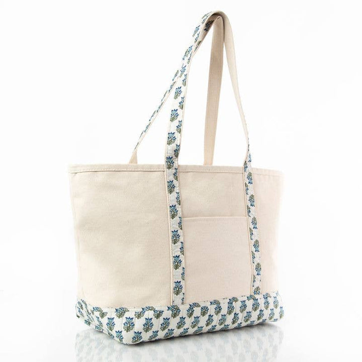 Beige tote bag with floral patterned handle and bottom edge on a white background