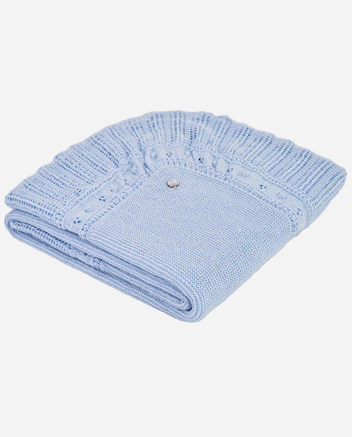 Folded light blue knitted blanket on a gray background