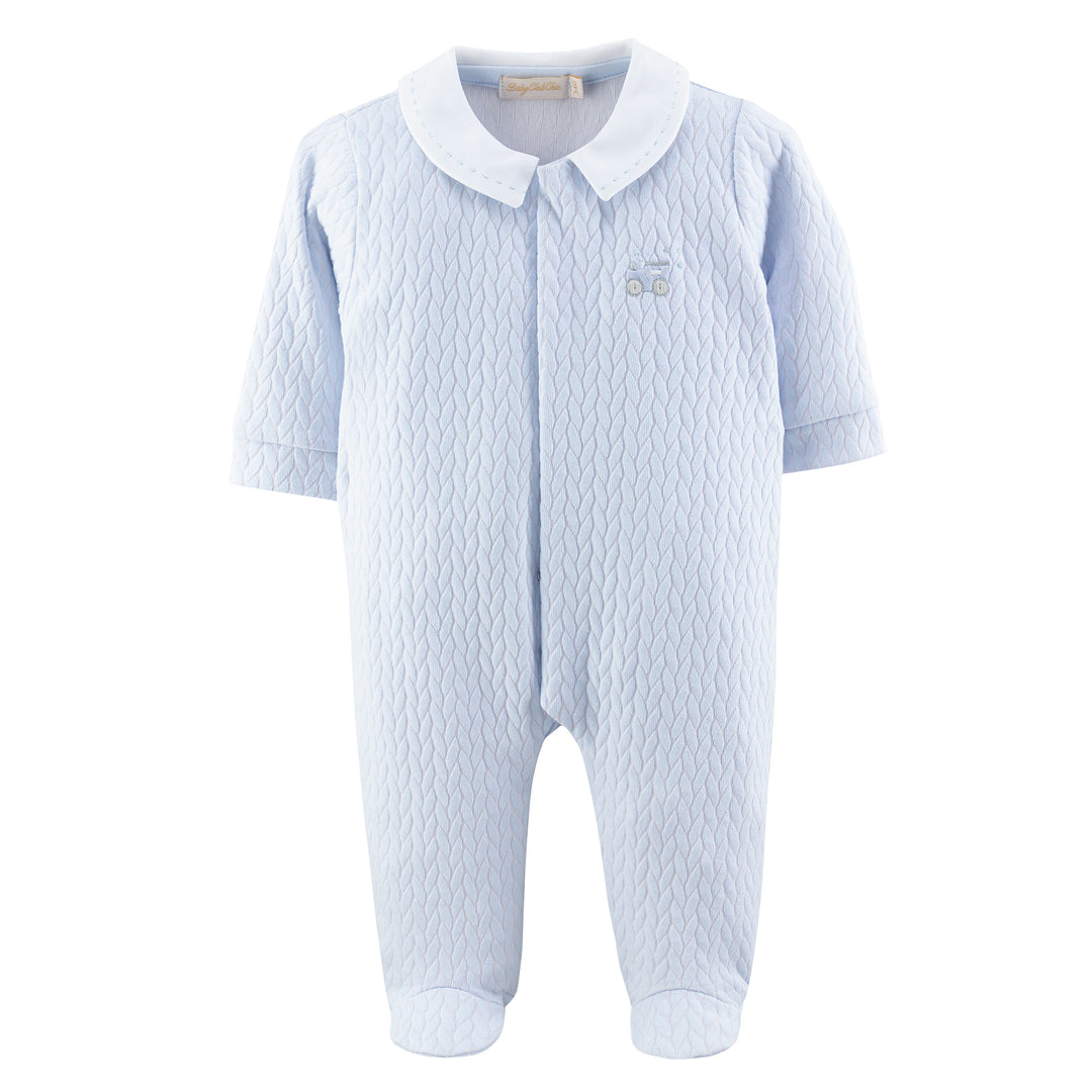 A light blue baby footed one-piece romper with a textured waffle pattern, featuring a contrasting white collar and a small embroidered car logo on the chest.