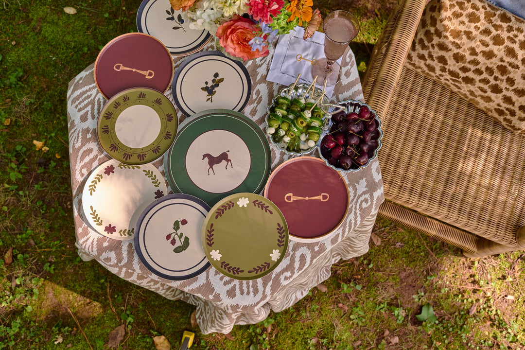 Table Two Studio paper plate collection on an outdoor picnic table, featuring the Botanica Blackberry plate