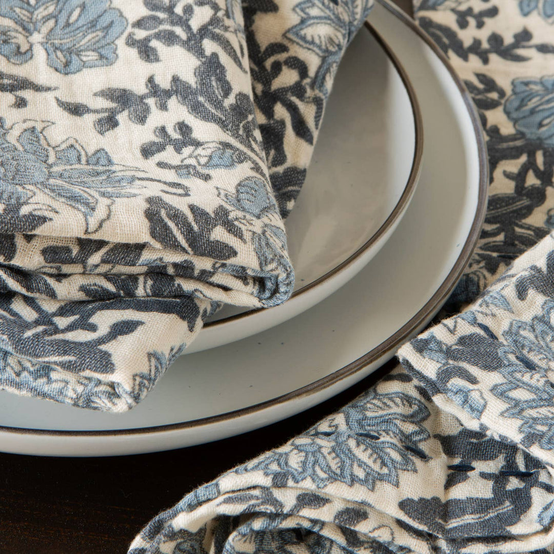 Floral-patterned cloth draped over a stack of plates on a dark surface