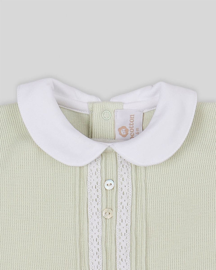 Close-up of a light green baby outfit with a white collar on a gray background