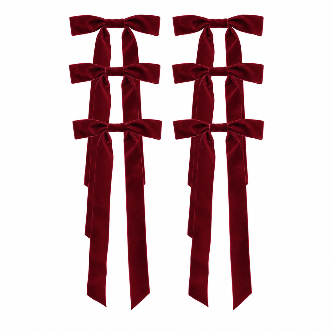 Four long burgundy velvet ribbon bows with long tails, arranged in two pairs on a plain white background.