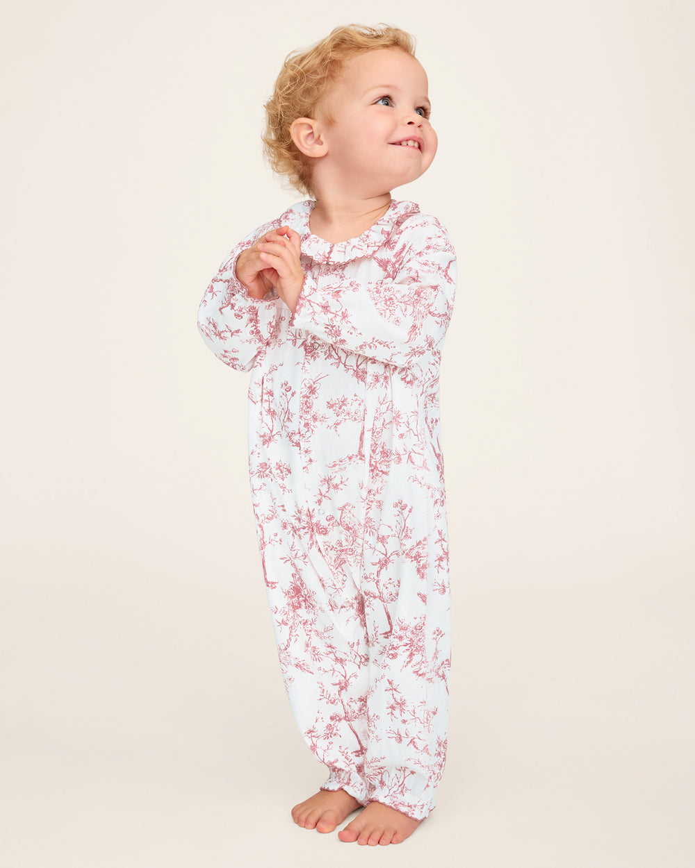 Child wearing a floral onesie on a plain background