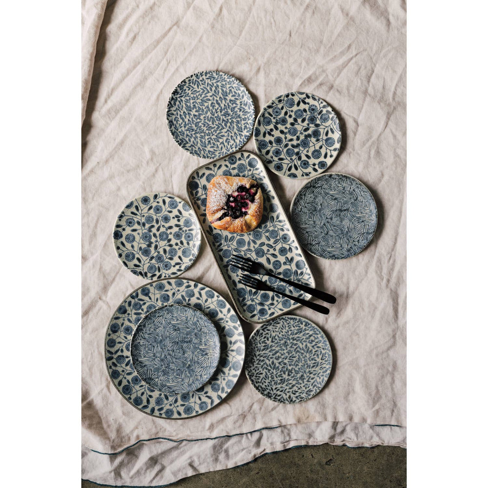 Set of ceramic plates with a textured design on a neutral fabric background
