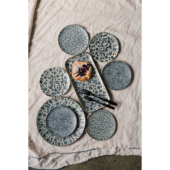 Set of ceramic plates with a textured design on a neutral fabric background