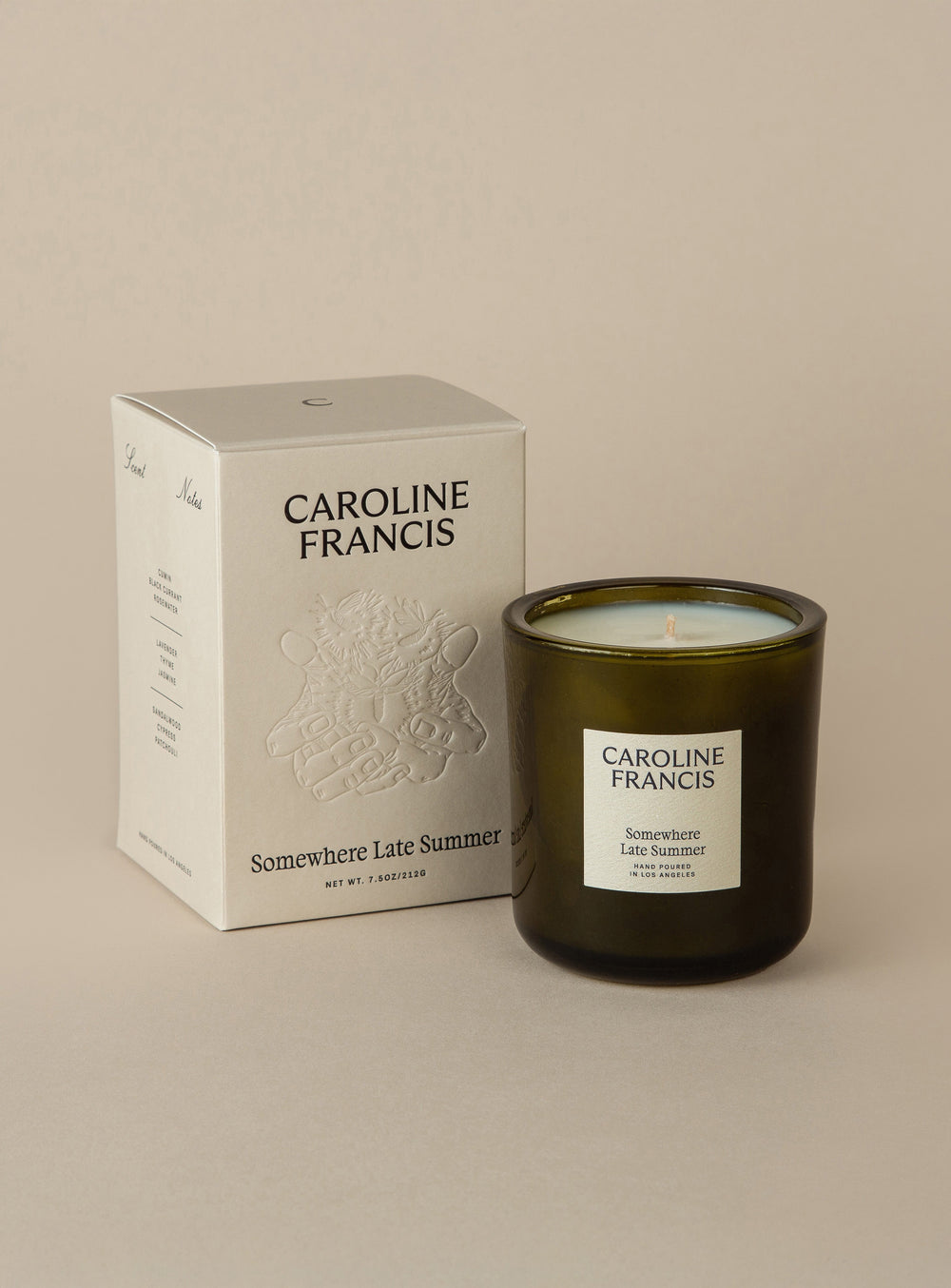 Caroline Francis candle and packaging on a beige background