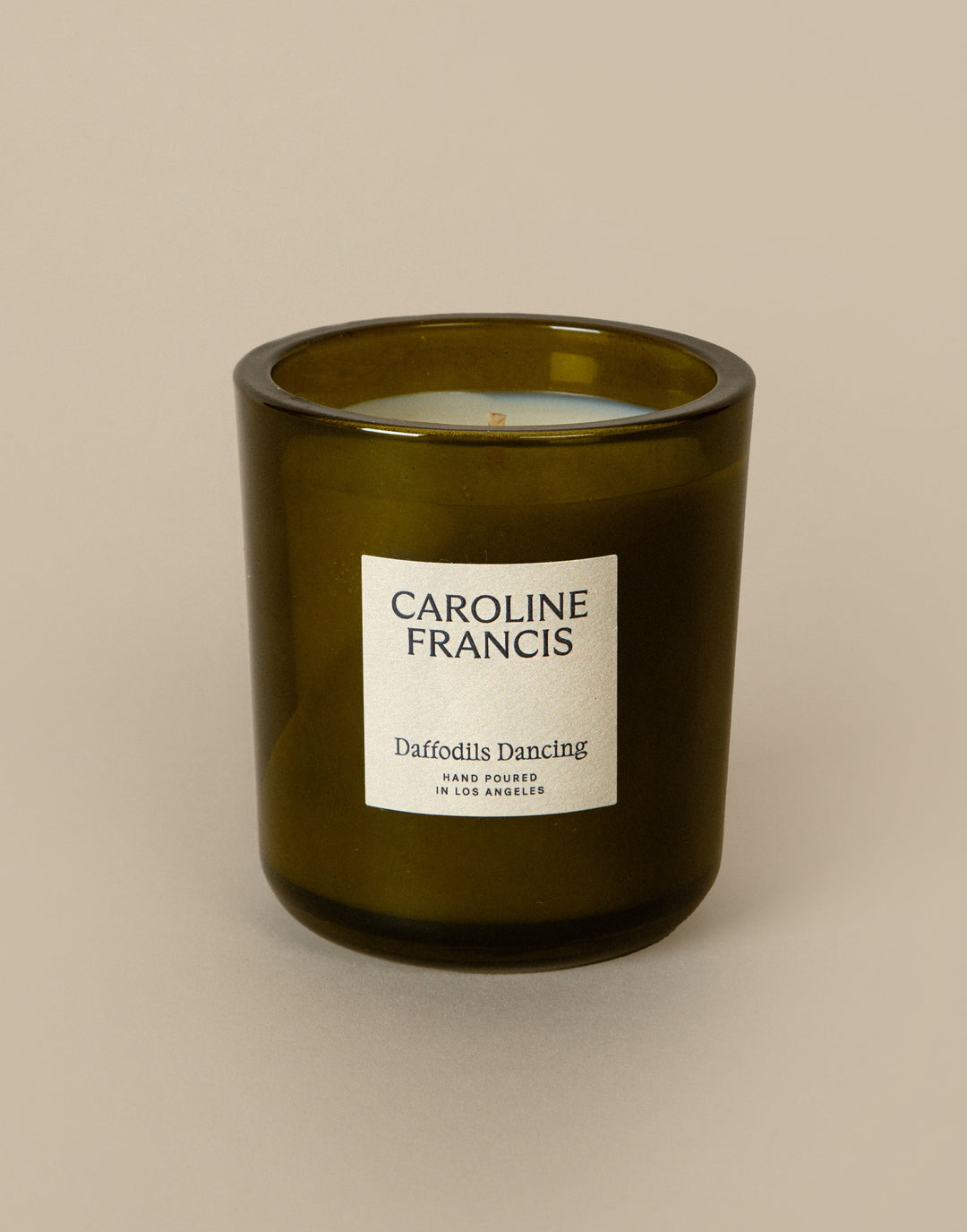 Green candle with a label on a beige background