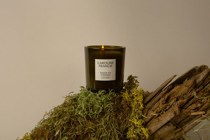 Candle with 'Caroline Francis' branding on a natural background