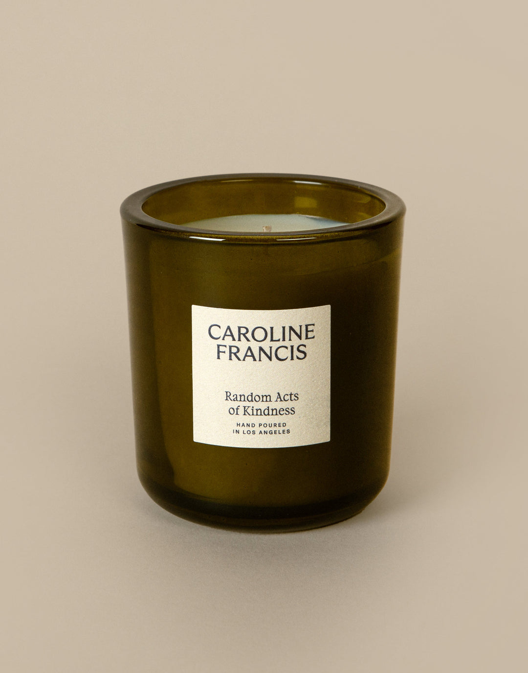 Green candle with a label on a beige background