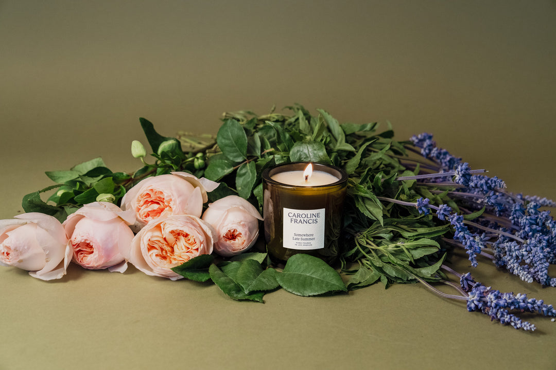 Candle with flowers and lavender on a green background