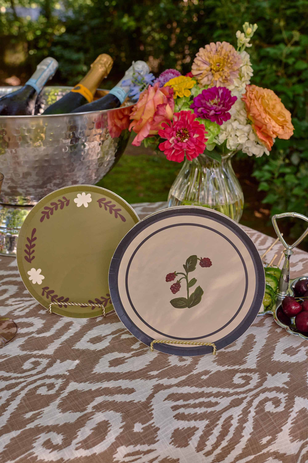 Table Two Studio paper plate collection styled on a table, featuring the Casa Dinner plate in Dirty Martini