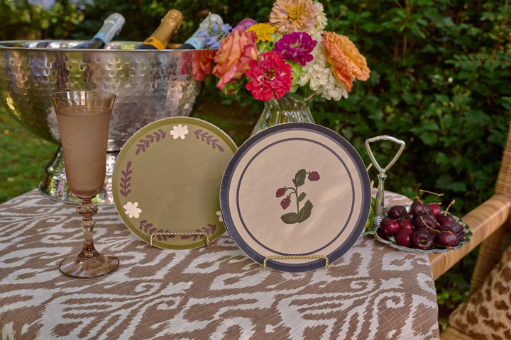 Botanica Raspberry and casa dirty martini paper plate styled with florals and a glass on an outdoor table setting