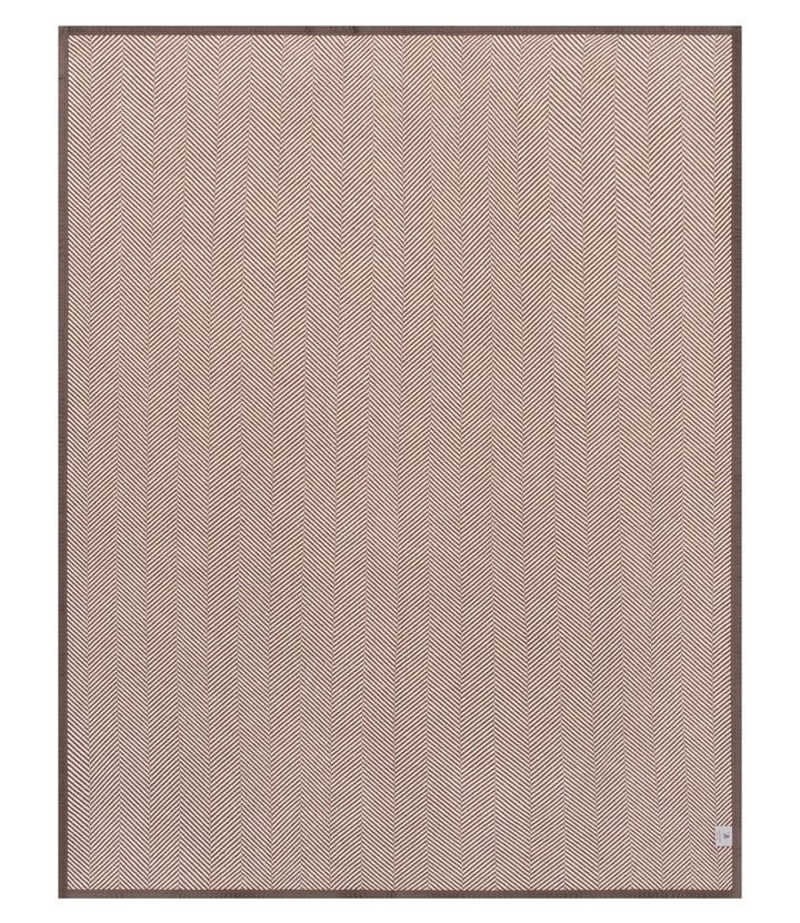 A square area rug with a fine herringbone pattern in a dusty rose pink color, finished with a dark brown border, shown flat against a white background.