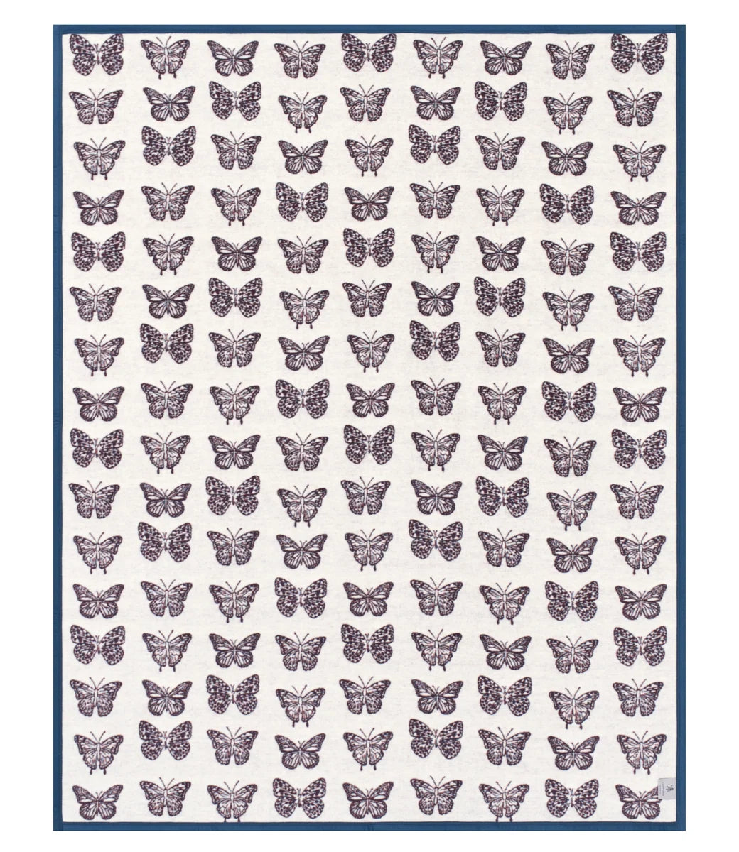 A square textile or print featuring a repeating pattern of purple butterflies on an off-white background, framed by a thin dark blue border.