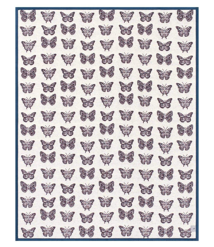 A square textile or print featuring a repeating pattern of purple butterflies on an off-white background, framed by a thin dark blue border.