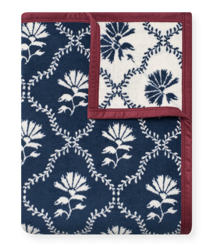 Floral patterned blanket with blue and white design on a white background