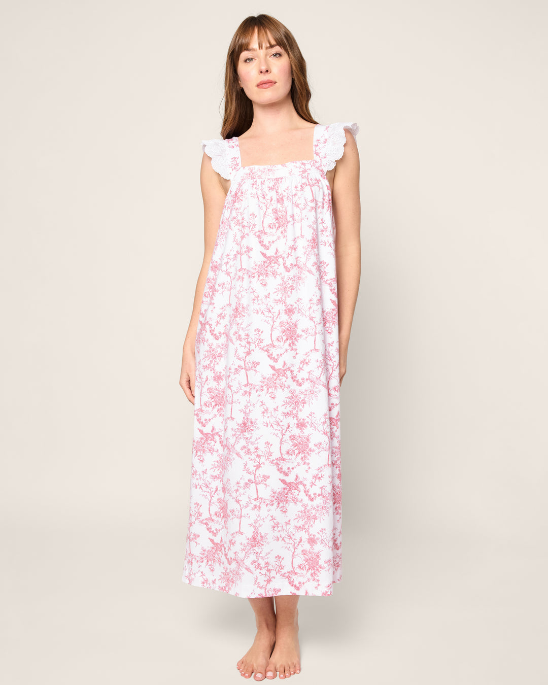 Woman wearing a floral nightgown against a plain background
