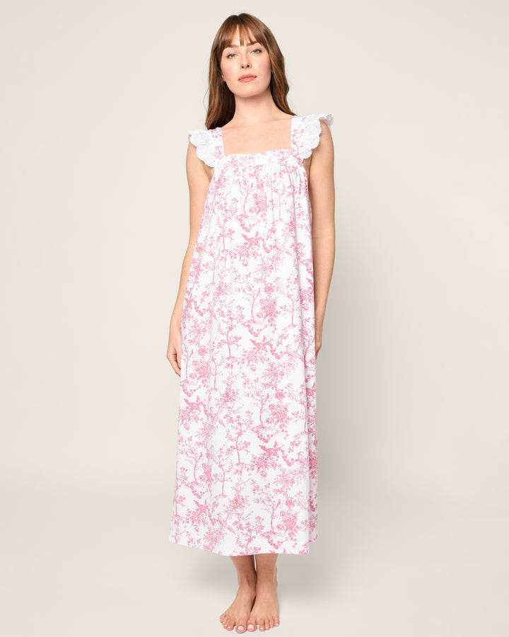 Woman wearing a floral nightgown against a plain background