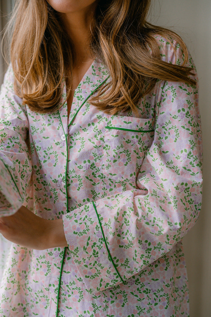 Person wearing a pink floral pajama set with green accents.