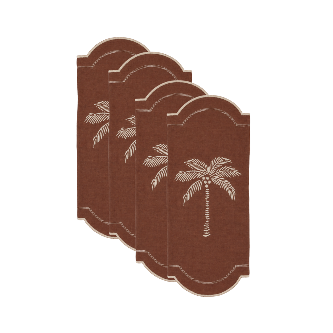 Four brown napkins with arched tops and embroidered palm tree designs, arranged in a staggered stack on a white background.