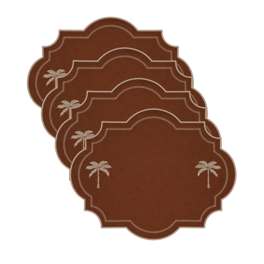 Four brown placemats with scalloped edges and small palm tree designs, arranged in a staggered stack on a white background.