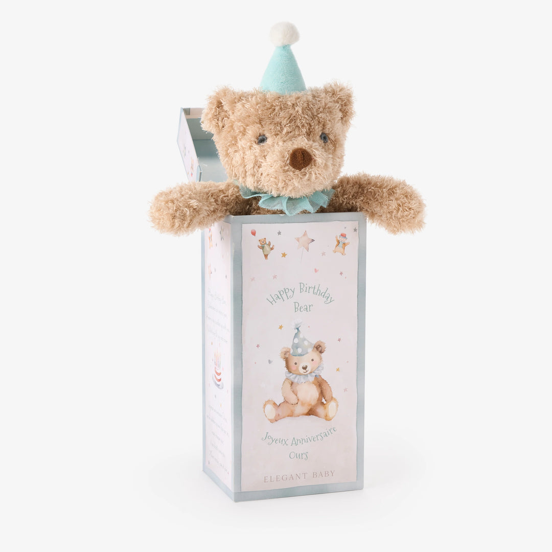 Teddy bear with a party hat in a gift box on a white background