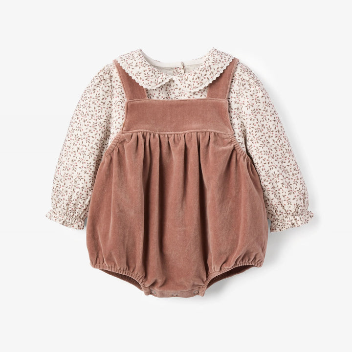 A baby girl's two-piece outfit featuring a dusty rose corduroy bubble romper with shoulder straps over a long-sleeve cream blouse with a tiny pink floral print and a white Peter Pan collar.