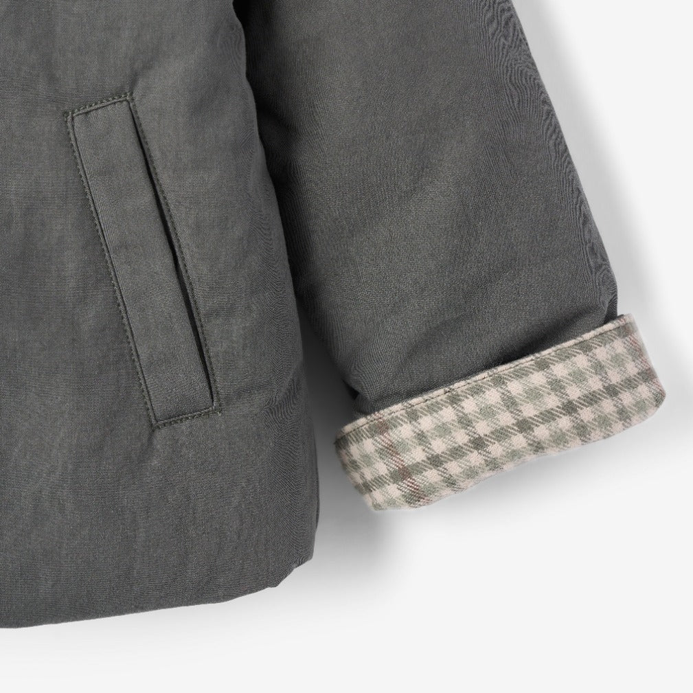 Close-up of a gray jacket with a checkered cuff on a white background