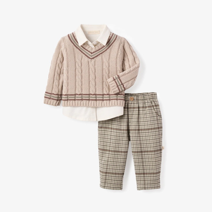 Children's outfit with cable knit sweater, plaid pants, and white shirt on a white background