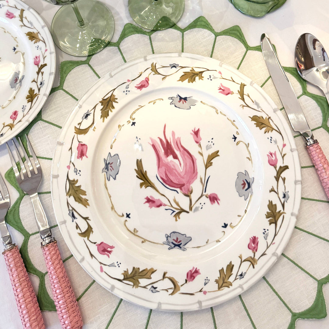 Decorative floral plate on a matching table setting with cutlery.