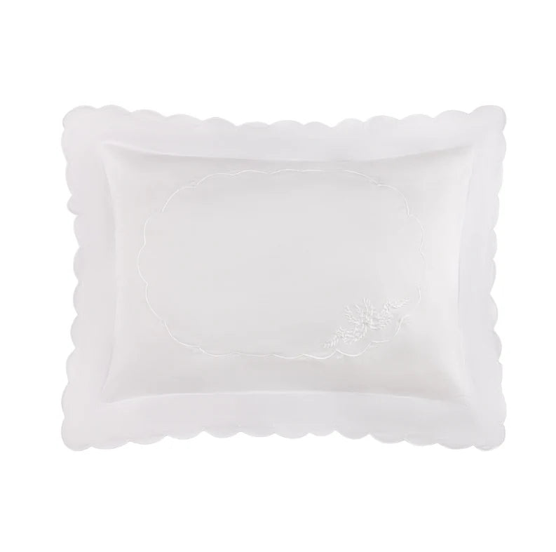 A white rectangular pillow sham with a scalloped border and subtle embroidered detailing, shown against a plain white background.