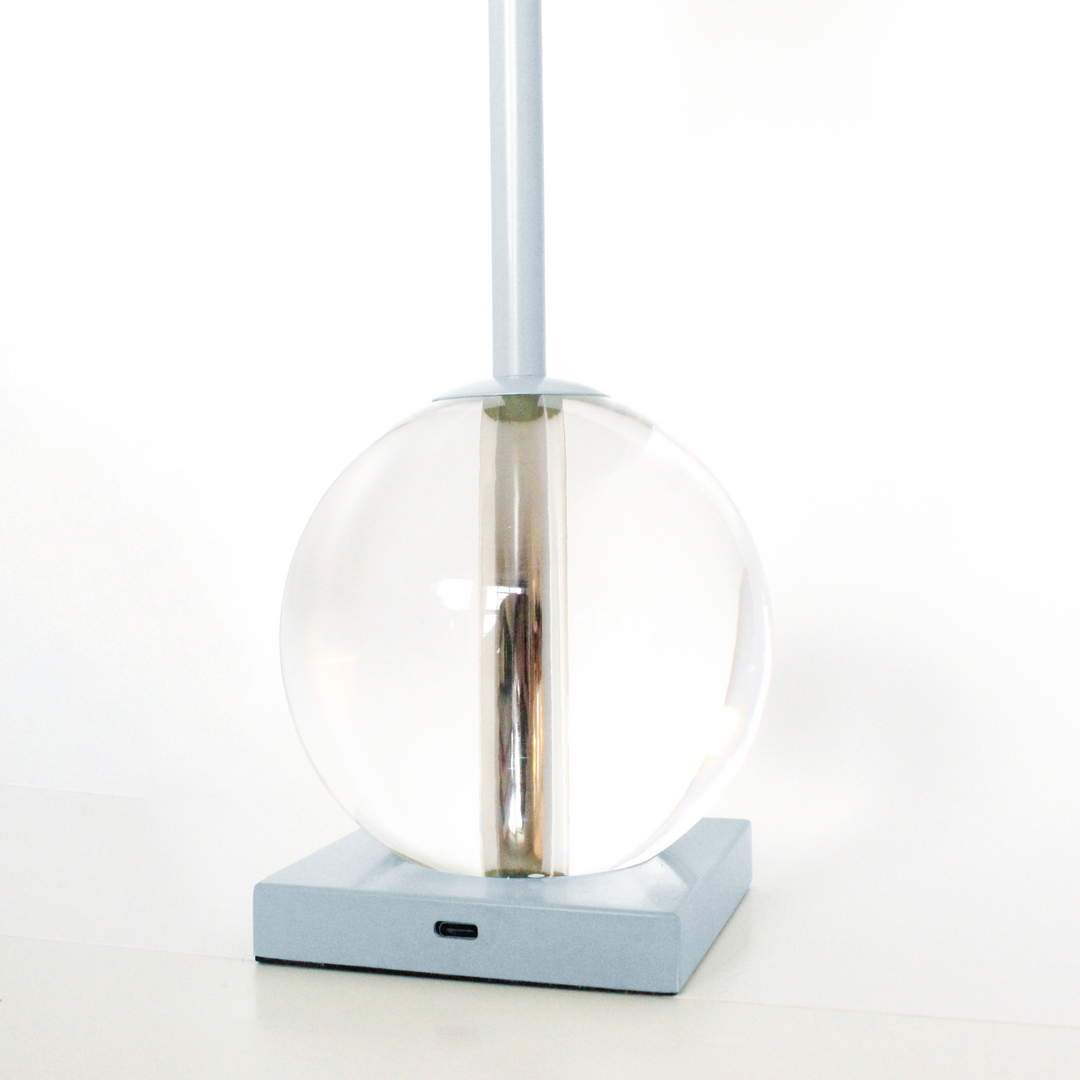 Modern pendant light with a clear glass shade and blue base on a white background