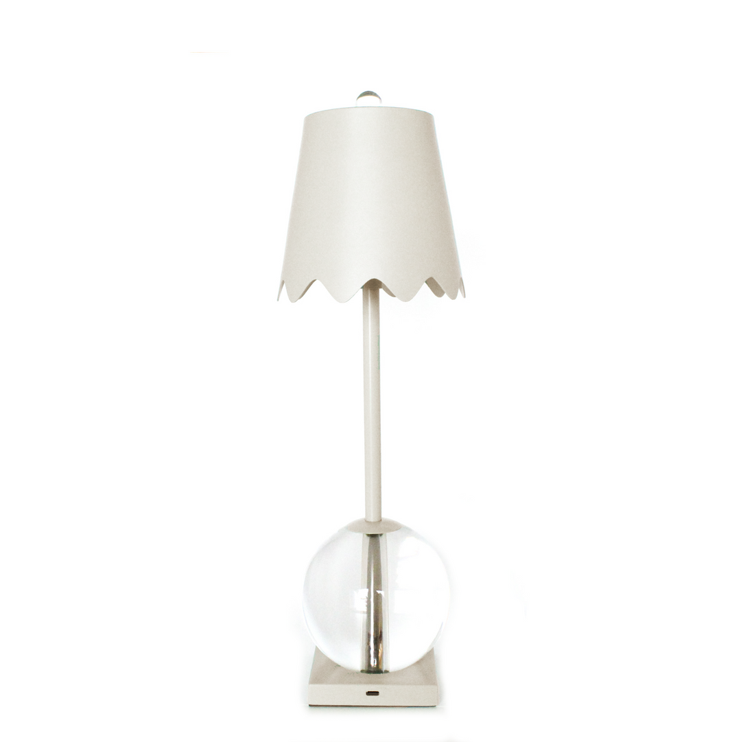Table lamp with a white shade and clear glass base on a white background