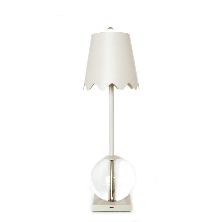 Table lamp with a white shade and clear glass base on a white background