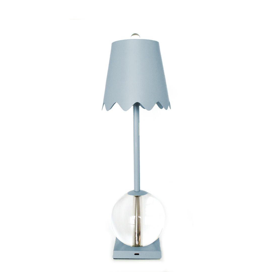 Blue table lamp with a scalloped shade on a white background