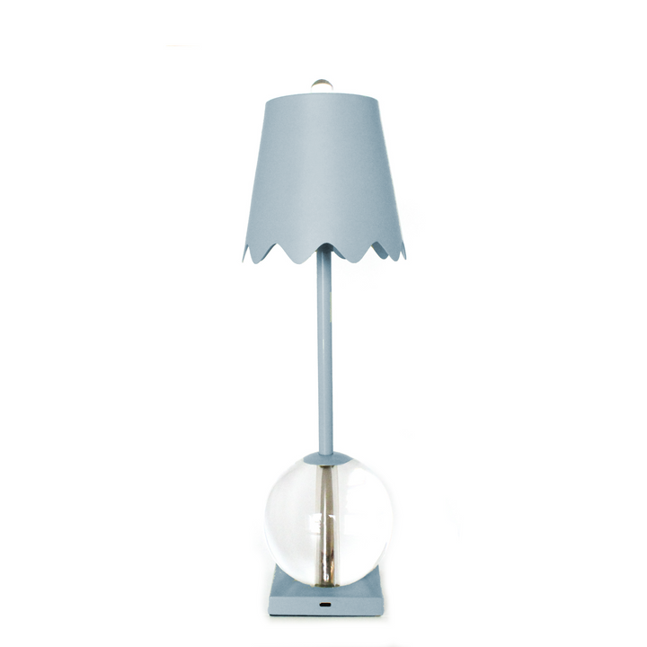 Blue table lamp with a scalloped shade on a white background