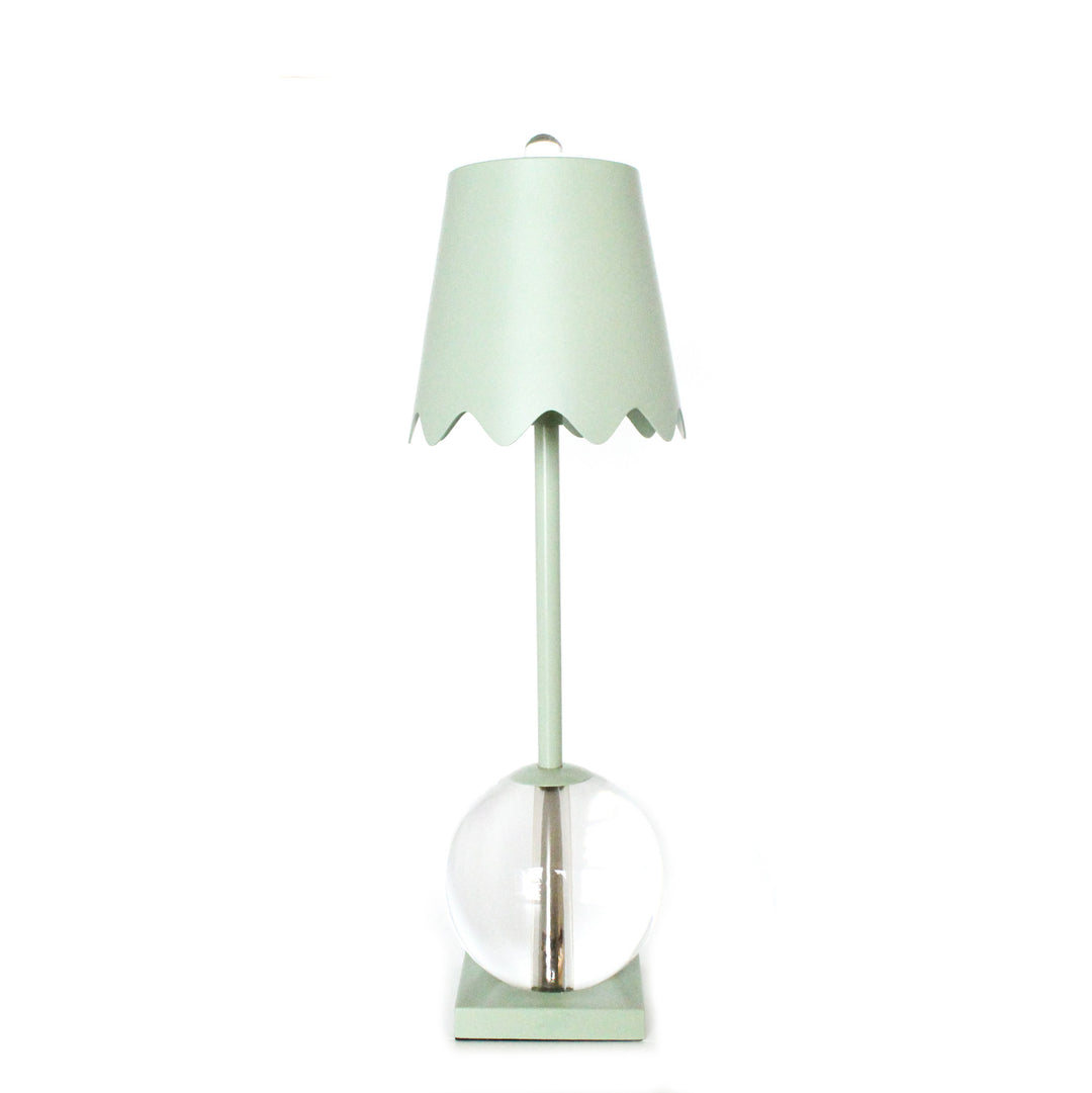 Mint green table lamp with a clear glass base on a white background